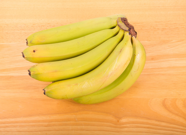 Plátanos verdes sobre tabla de madera
 - Foto, Imagen