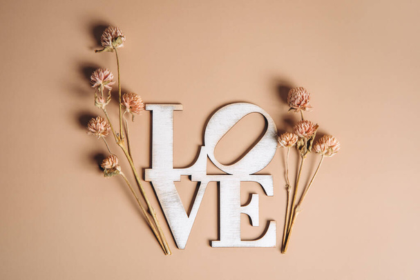 Creative flat lay of word love on soft color  background with natural plants.  - Foto, imagen