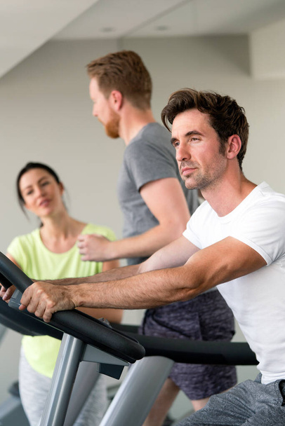 Group of fit people at the gym exercising on the cardio machines - Photo, Image