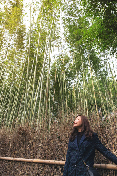 Красивая азиатская женщина с бамбуковым лесом на заднем плане - Фото, изображение