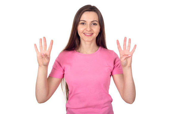 Woman in a pink sweater shows 8 fingers as the number eight. - Foto, Imagem