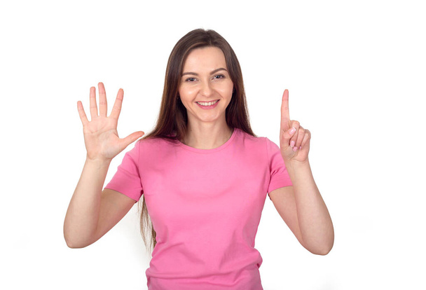 Young woman in a pink sweater shows 6 fingers as the number six. - Zdjęcie, obraz