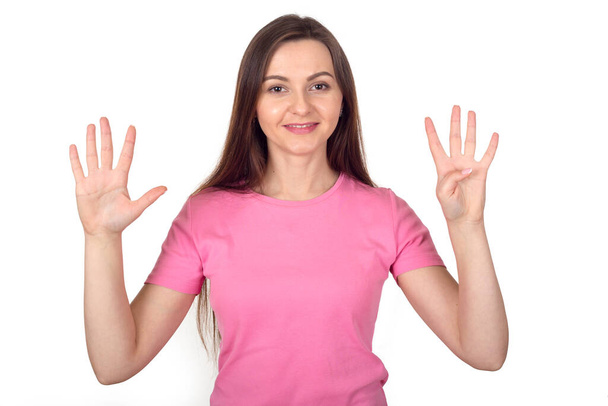 Young woman in pink sweater shows 9 fingers as number nine, isolated on white background. - Fotoğraf, Görsel