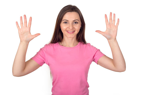 Happy brunette woman in pink sweater shows 10 fingers as the number ten. - Фото, зображення