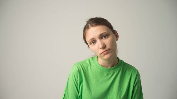 young beautiful sad woman serious and concerned looking worried and thoughtful facial expression feeling depressed isolated grey background in sadness and sorrow emotion - Photo, Image