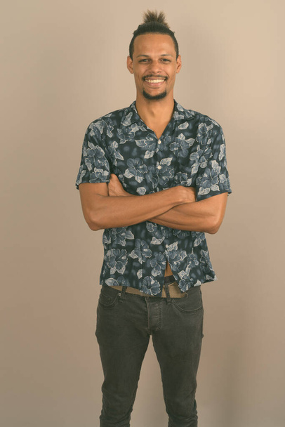 Young bearded handsome African man against gray background - Φωτογραφία, εικόνα