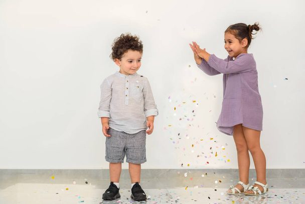 Cute dzieci korzystających z wakacji i rzucanie confetti. - Zdjęcie, obraz