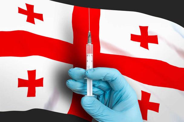 Vacunación en Georgia. Vacuna para proteger contra el Covid-19 en el fondo de la bandera nacional. - Foto, Imagen