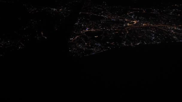 nocny pejzaż miasta z okna samolotu, koncepcja podróży i turystyki - Materiał filmowy, wideo