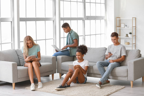 Teenagers with different devices at home - Foto, imagen