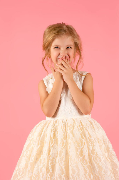 little girl in white dress smiling isolated on pink background - Foto, imagen