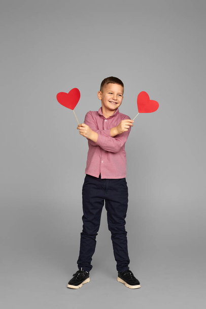 Ημέρα του Αγίου Βαλεντίνου. χαριτωμένο μικρό αγόρι κρατώντας κόκκινη καρδιά - Φωτογραφία, εικόνα