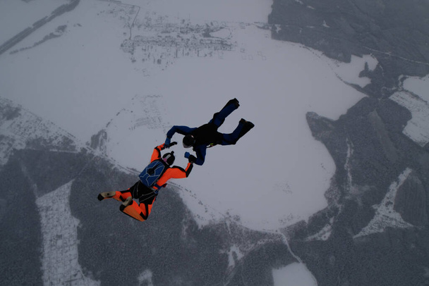 Прыжки с парашютом Командный прыжок. Два парашютиста тренируются в небе. - Фото, изображение
