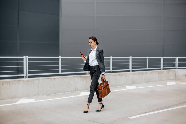A business woman checks the time in the city during a working day waiting for a meeting. Discipline and timing. An employee goes towards a corporate meeting. - Fotografie, Obrázek