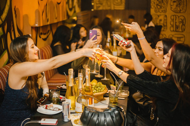 группа девушек празднует Новый год в ночном клубе и делает сюжет по телефону - Фото, изображение