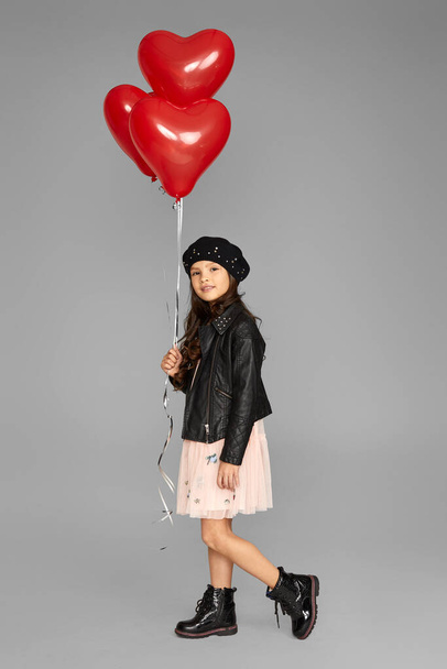 happy child girl holding red heart shaped balloon - Foto, Imagen