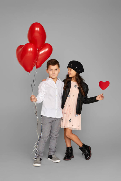 couple of little girl and boy with red heart balloons - Foto, Imagem