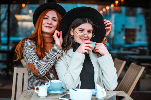 Two girl friends drinking coffee in the cafe - Fotó, kép