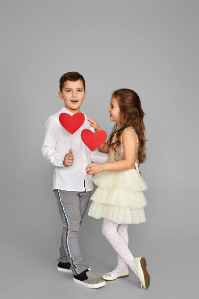 Happy couple little girl and boy with red hearts - Fotó, kép