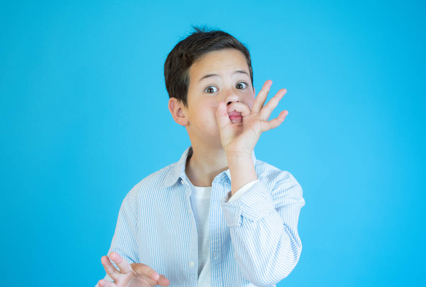 Boy showing okay gesture in sign language on blue background - Фото, зображення