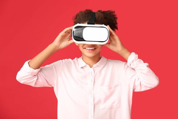 Adolescente afroamericana chica con gafas de realidad virtual sobre fondo de color - Foto, imagen