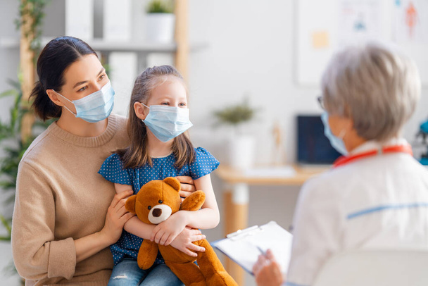Doctor, child and mother wearing facemasks during coronavirus and flu outbreak. Virus protection. COVID-2019. Taking on masks. - Photo, Image