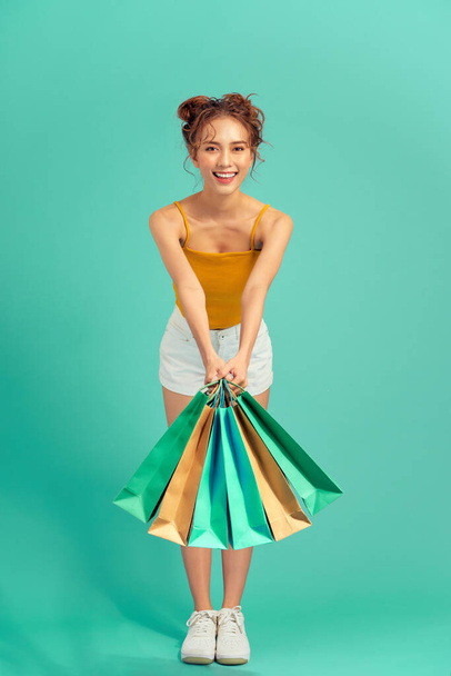 Beautiful Asian woman are shopping In the summer over light green background. - Zdjęcie, obraz