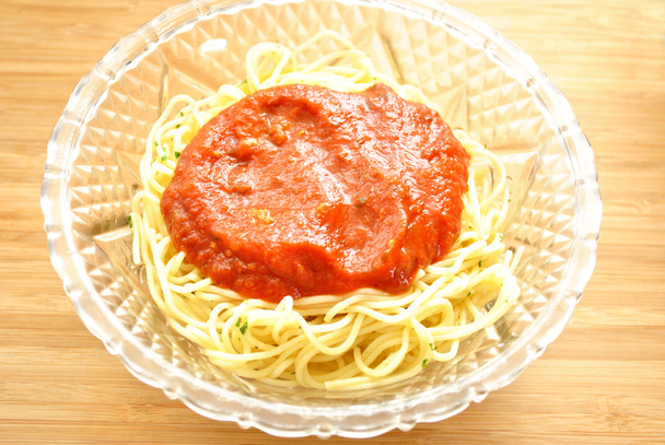 Тонкие спагетти с соусом в стеклянной чаше
 - Фото, изображение