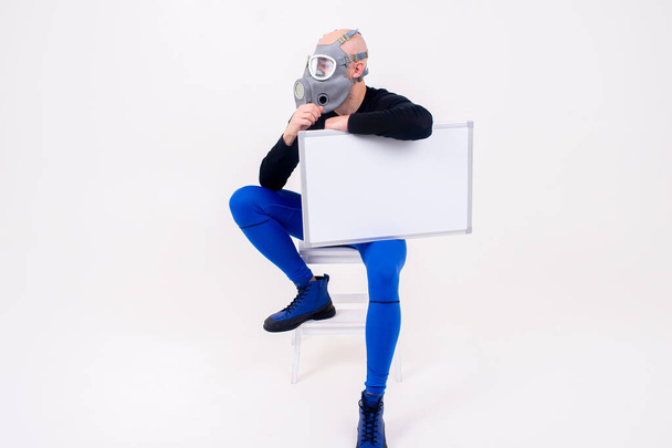 Funny strange man in respirator sitting on stepladder with a marker board  over white background - Foto, immagini