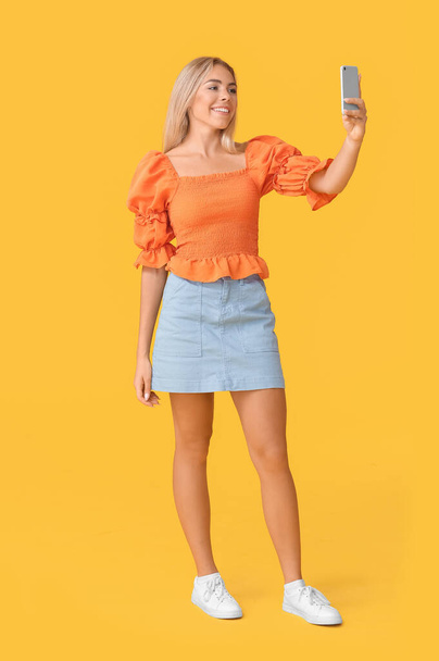 Teenage girl taking selfie on color background - Photo, image