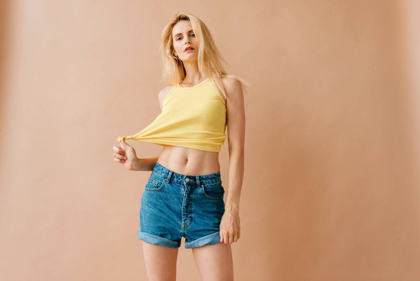 Beautiful young blonde model in casual clothes posing in studio - Foto, immagini
