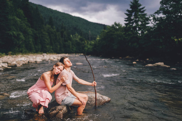 Lifestyle loving couple hugging at stone in the river. - Foto, Bild
