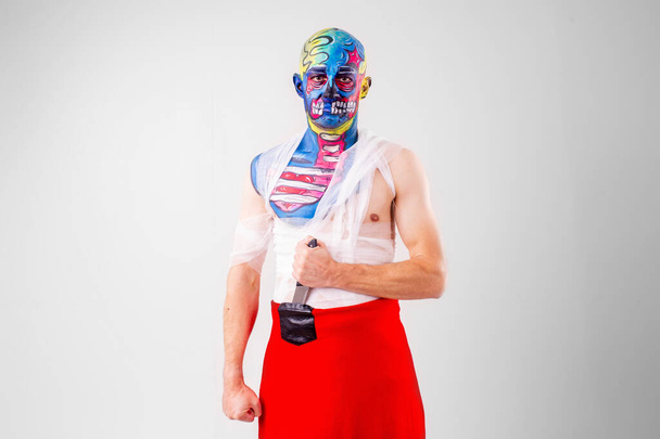 A strange man with makeup on his head and shoulder in white t-shirt, red pants - Foto, Bild