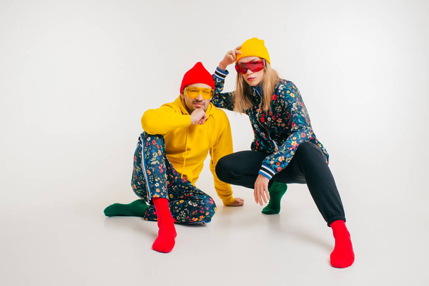 Stylish couple of man and woman in colorful clothes posing over white background - Valokuva, kuva