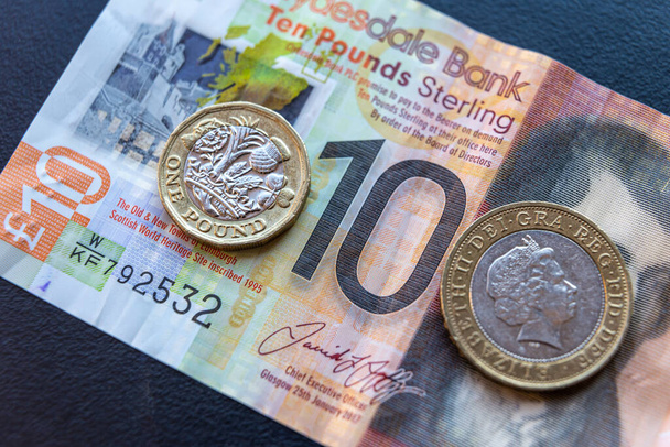 10 pond biljet, met 1 en 2 munten bovenop. Brexit en sterling wisselkoers. - Foto, afbeelding