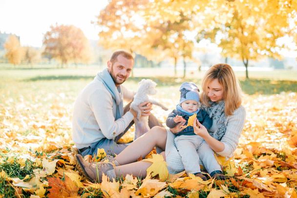 Happy family with their baby outdoor portrait in autumn park. - Zdjęcie, obraz