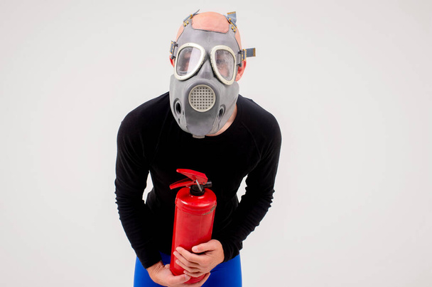 Funny strange man in respirator with fire extinguisher posing over white background - Zdjęcie, obraz