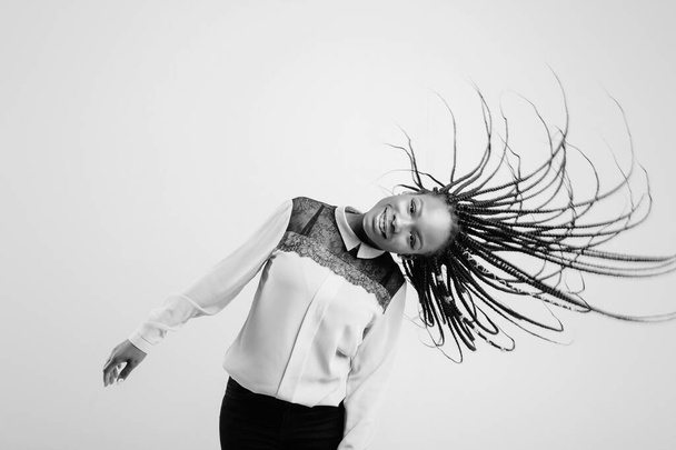 Happy cheerful african american girl shaking her head with dreadlocks on white background. - Foto, Imagen