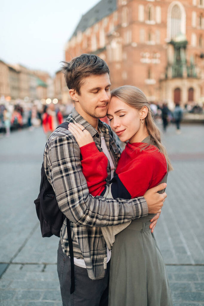 Young loving couple hugs at central square in Krakow (Cracow) - Valokuva, kuva