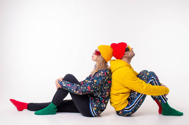 Stylish couple of man and woman in colorful clothes posing over white background - Photo, image