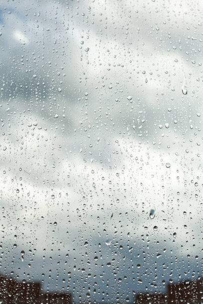 Yağmur damlalarının düştüğü pencereyi kapat. Yağmur damlalarına odaklan. Yağmurlu bir günde, pencerenin dışındaki camlarda bulanık kenarlı yağmur damlaları. Bahar günü pencere camına yağmur yağar. - Fotoğraf, Görsel