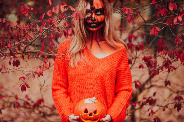 Young blonde girl with halloween face art posing outdoor.  Helloween celebration concept. - Foto, Imagem