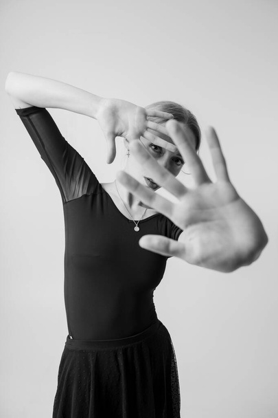Black and white picture of beautiful young fit woman doing sport exercises in big bright white studio - Foto, afbeelding
