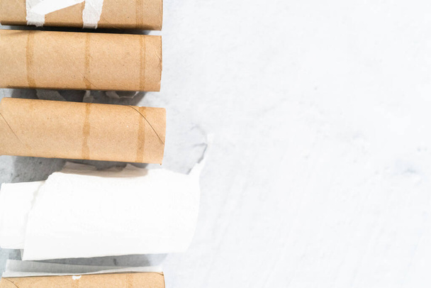 Used empty toilet paper rolls on a gray background. - Photo, image