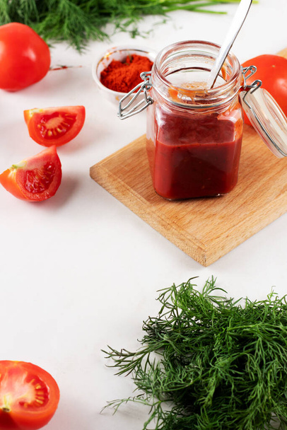  Kotitekoinen ketsuppi tomaateilla, paprikalla ja valkosipulilla. Tölkki tomaattikastiketta tuoretta tomaattia ja tilliä - Valokuva, kuva