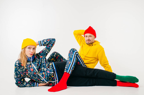 Stylish couple of man and woman in colorful clothes posing over white background - Valokuva, kuva