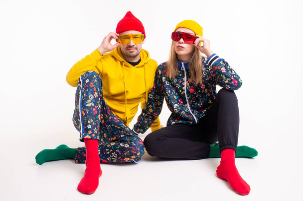 Stylish couple of man and woman in colorful clothes posing over white background - Fotó, kép