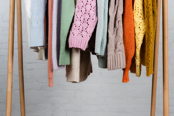 Pletené svetry na dřevěné věšák na bílém pozadí - Fotografie, Obrázek