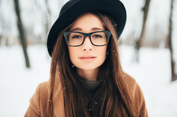 Closeup portrait of beautiful long haired brunnette girl with georgian appearance wearing glasses and looking at camera. - Photo, Image