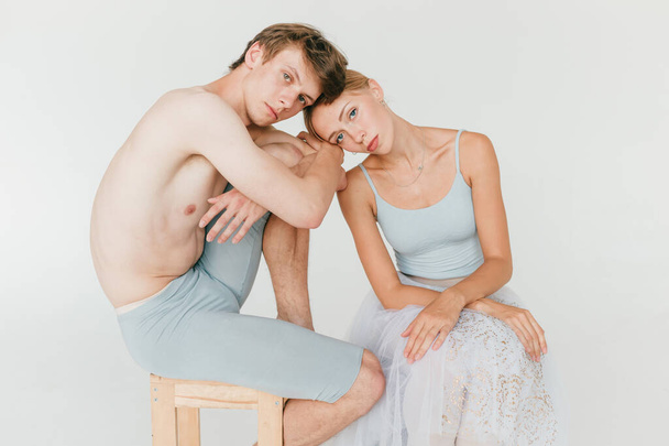 Beautiful couple of ballet dancers lifestyle portrait over white studio background - Fotó, kép